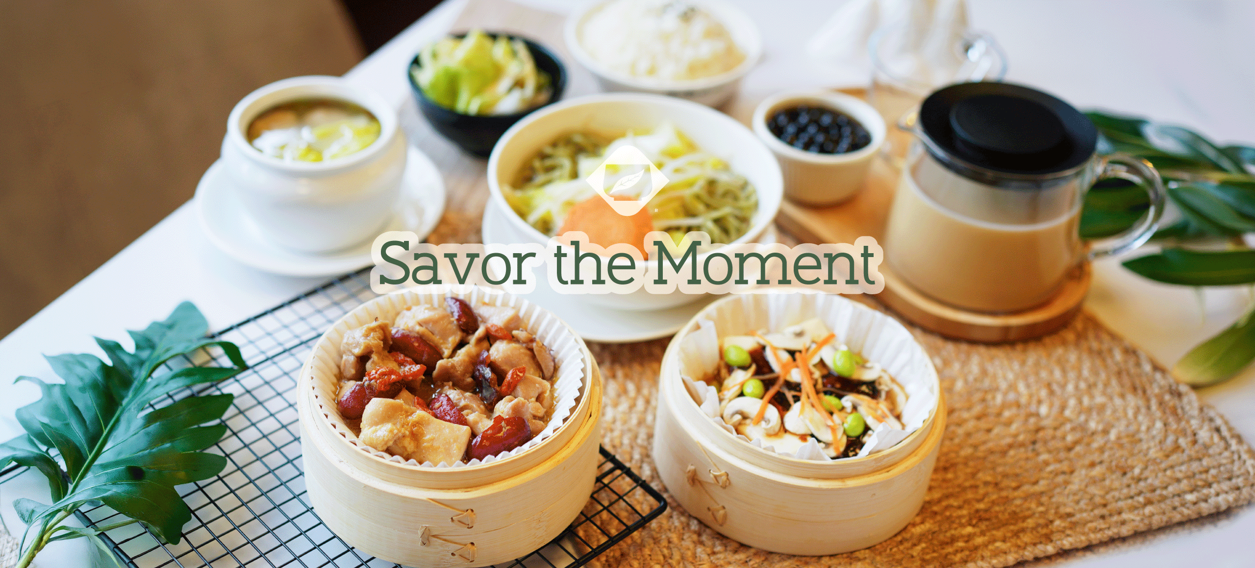 Assorted Asian dishes served in bamboo steamers and bowls with a teapot on a table